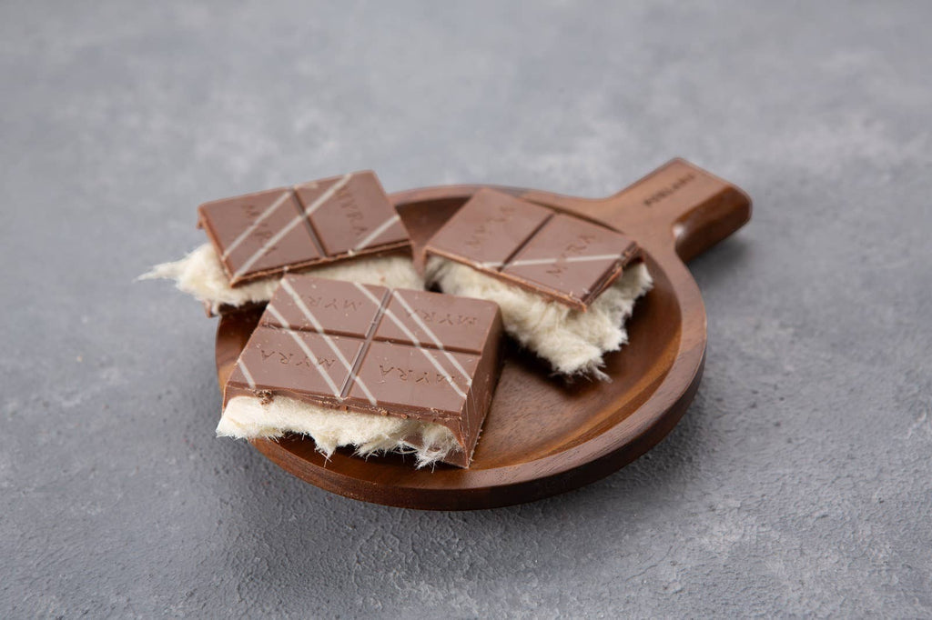 Candy Shack viral angel hair chocolate bars with milk chocolate and vanilla cotton candy filling on a wooden plate.