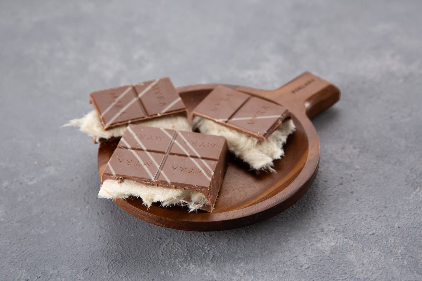 Candy Shack viral angel hair chocolate bars with milk chocolate and vanilla cotton candy filling on a wooden plate.